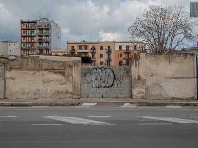 Ci rimettiamo quindi sui nostri passi. Superato sulla destra il centro di conferimento rifiuti dell�Amiu e un�azienda per materiali di edilizia, eccoci davanti a un emblematico simbolo della strada, oggi murato: le ex stalle del boss di Japigia Savinuccio Parisi, che qui ci portava i suoi cavalli